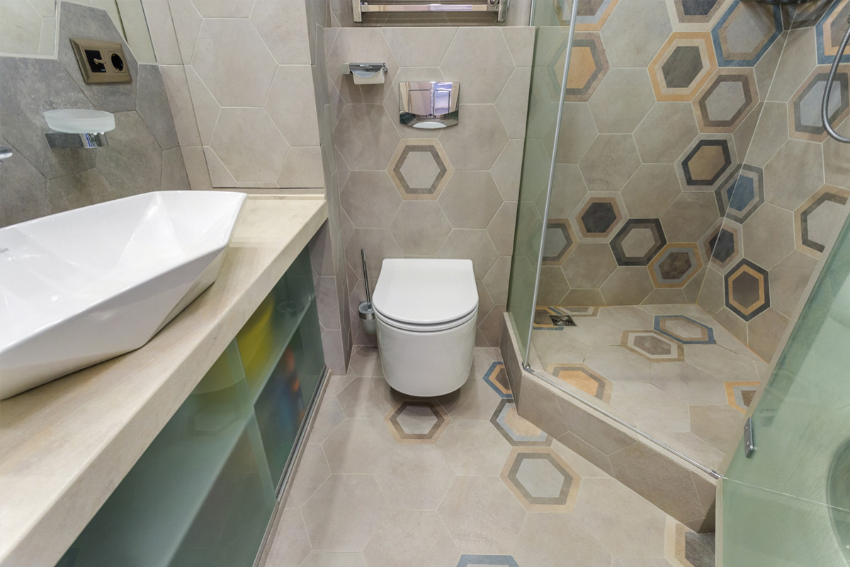 Ванная комната отделана шестигранной плиткой под бетон с рисунком фирмы Vives.